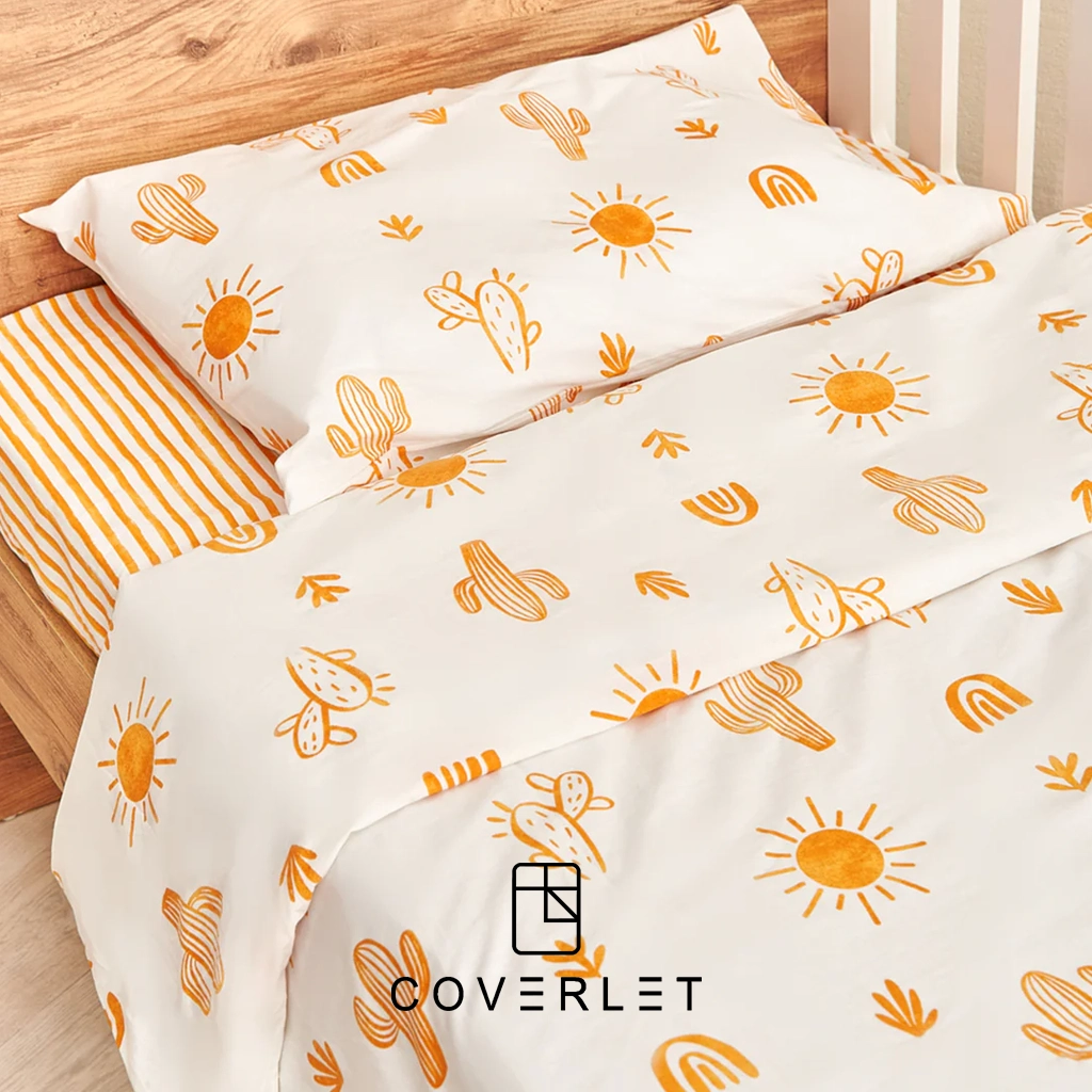 نمای نزدیک روتختی نوزادی مدل Boho روی تخت چوبی با نقوش نارنجی کاکتوس، خورشید، رنگینکمان و روبالشی هماهنگ روی زمینه سفید.
